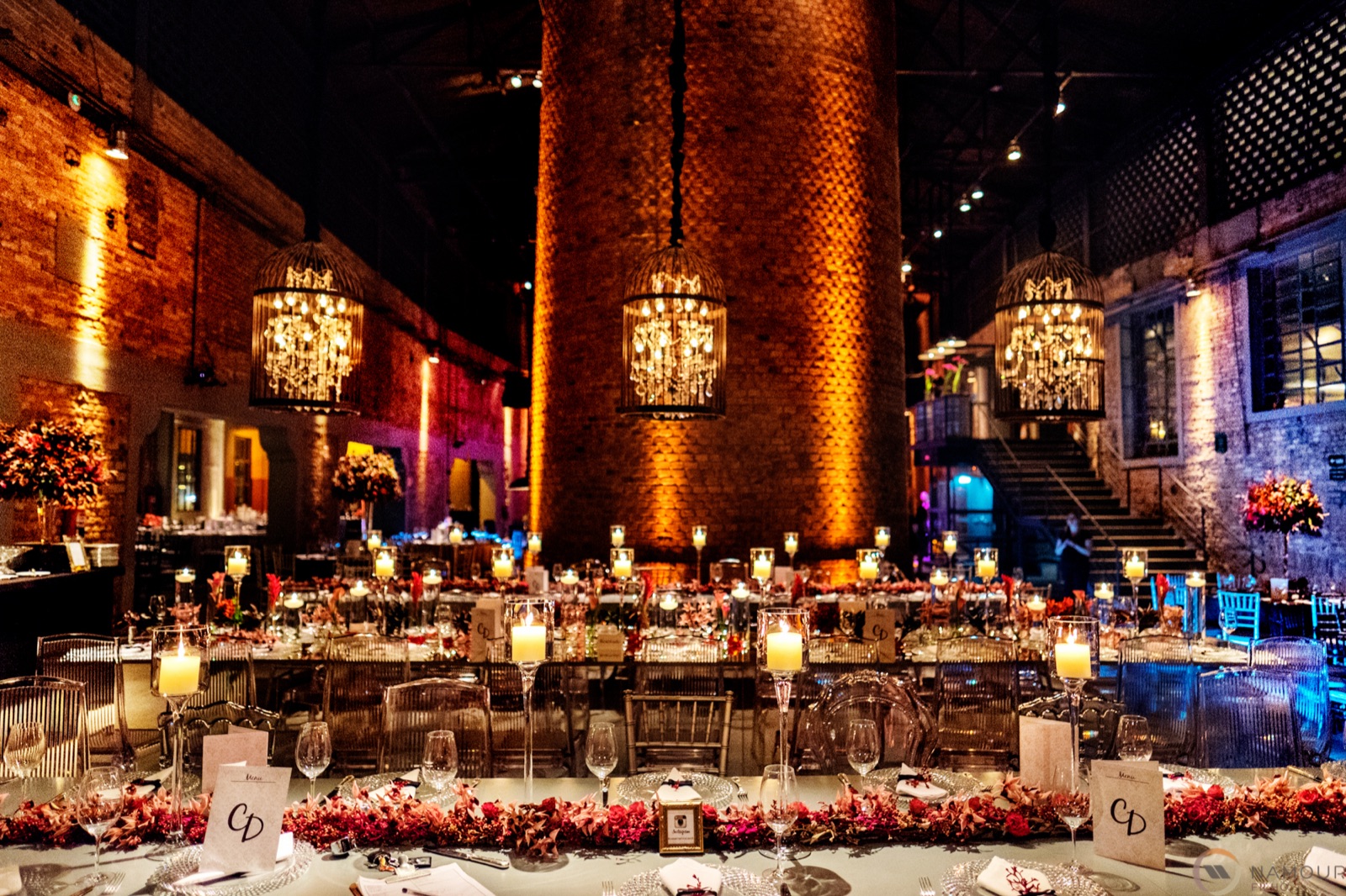 Casamento: mesas com velas, cristais e arranjos sob lustres